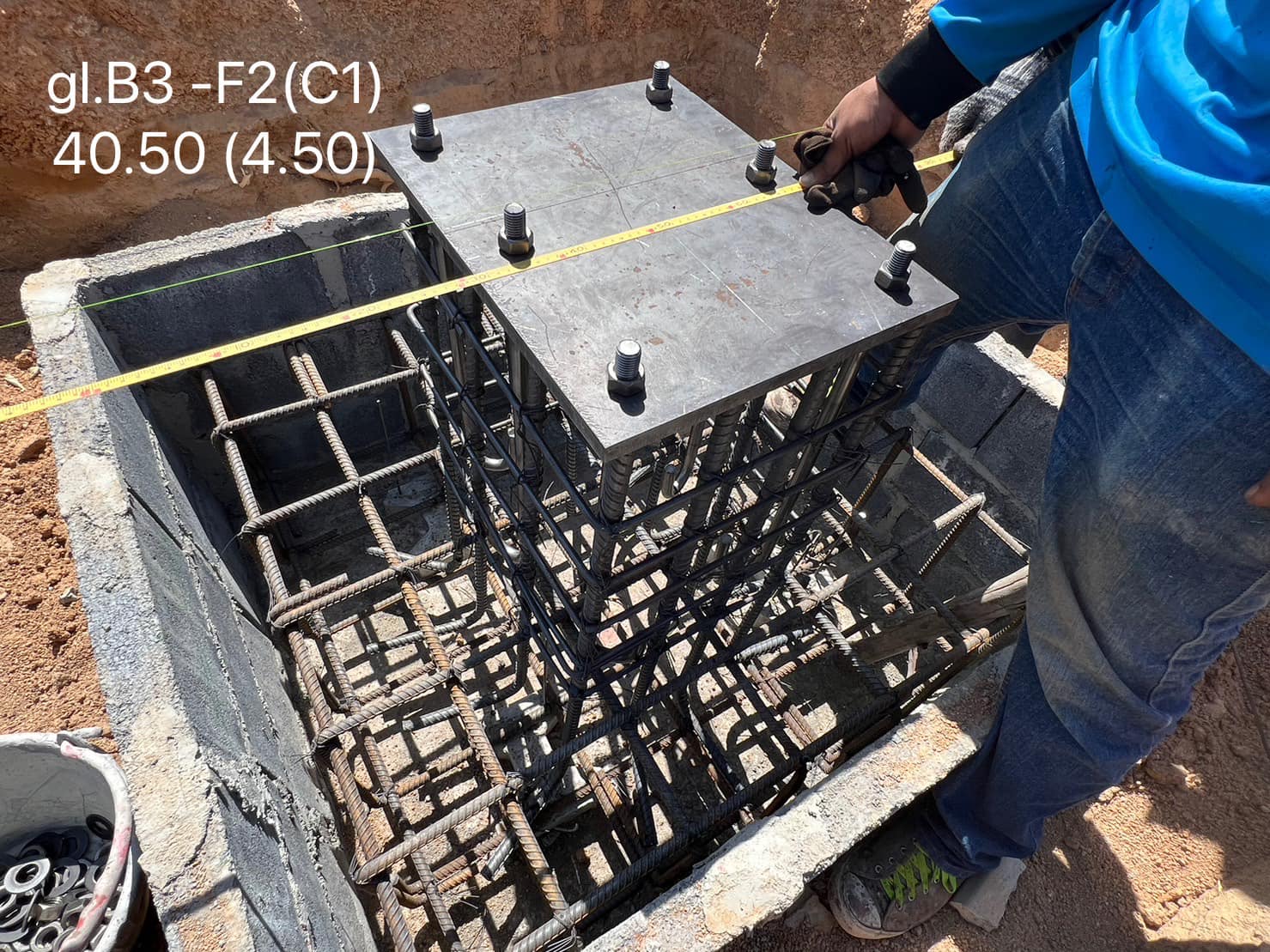แผ่นเหล็กรับเสา (base plate) พร้อมสลักยึดและเหล็กเสริมตอม่อ — สนามกีฬามีหลังคาคลุม โรงเรียนอรวินวิทยา ระยอง